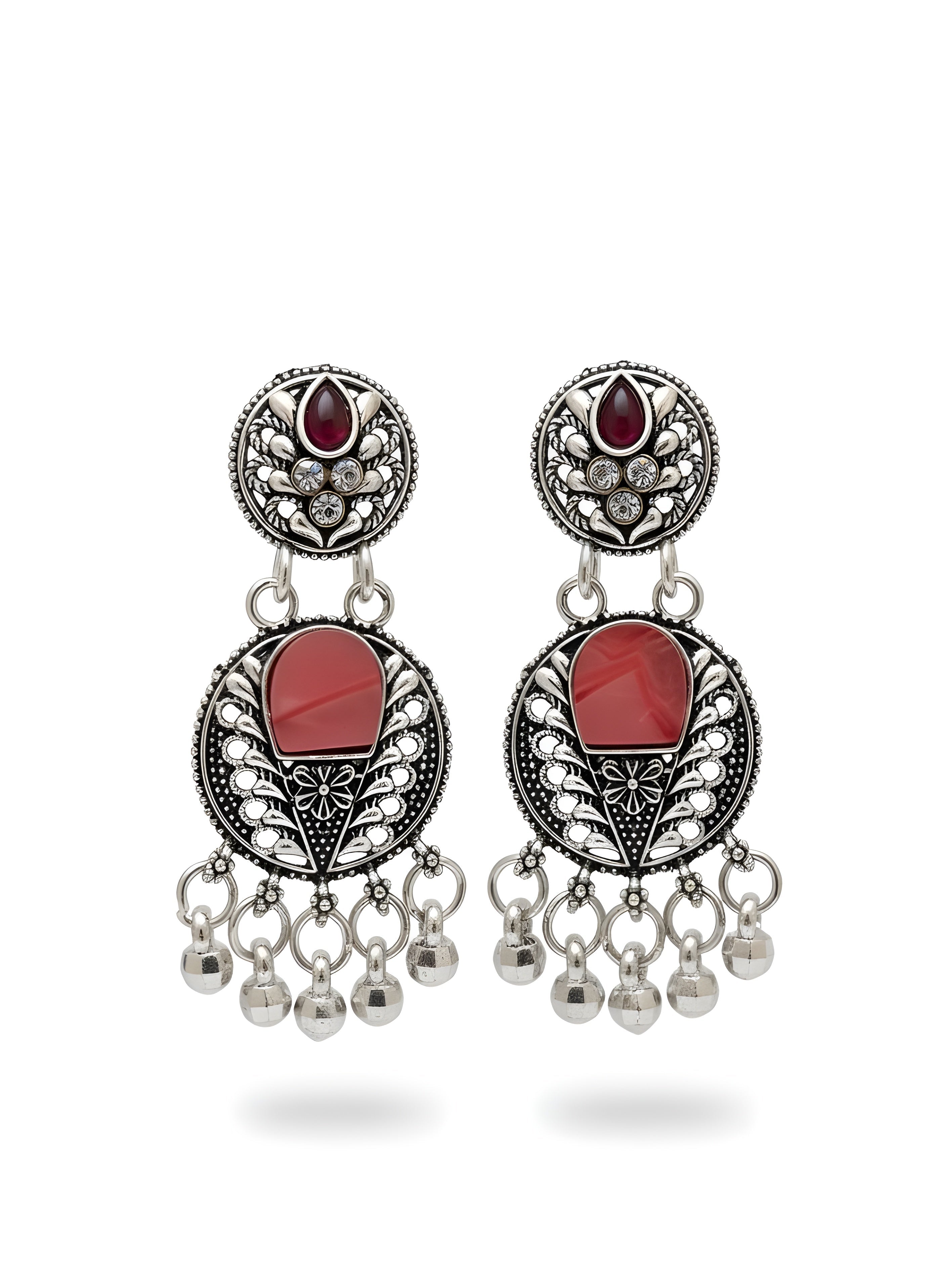 Pair of earrings with red stones and dangling beads on a white background