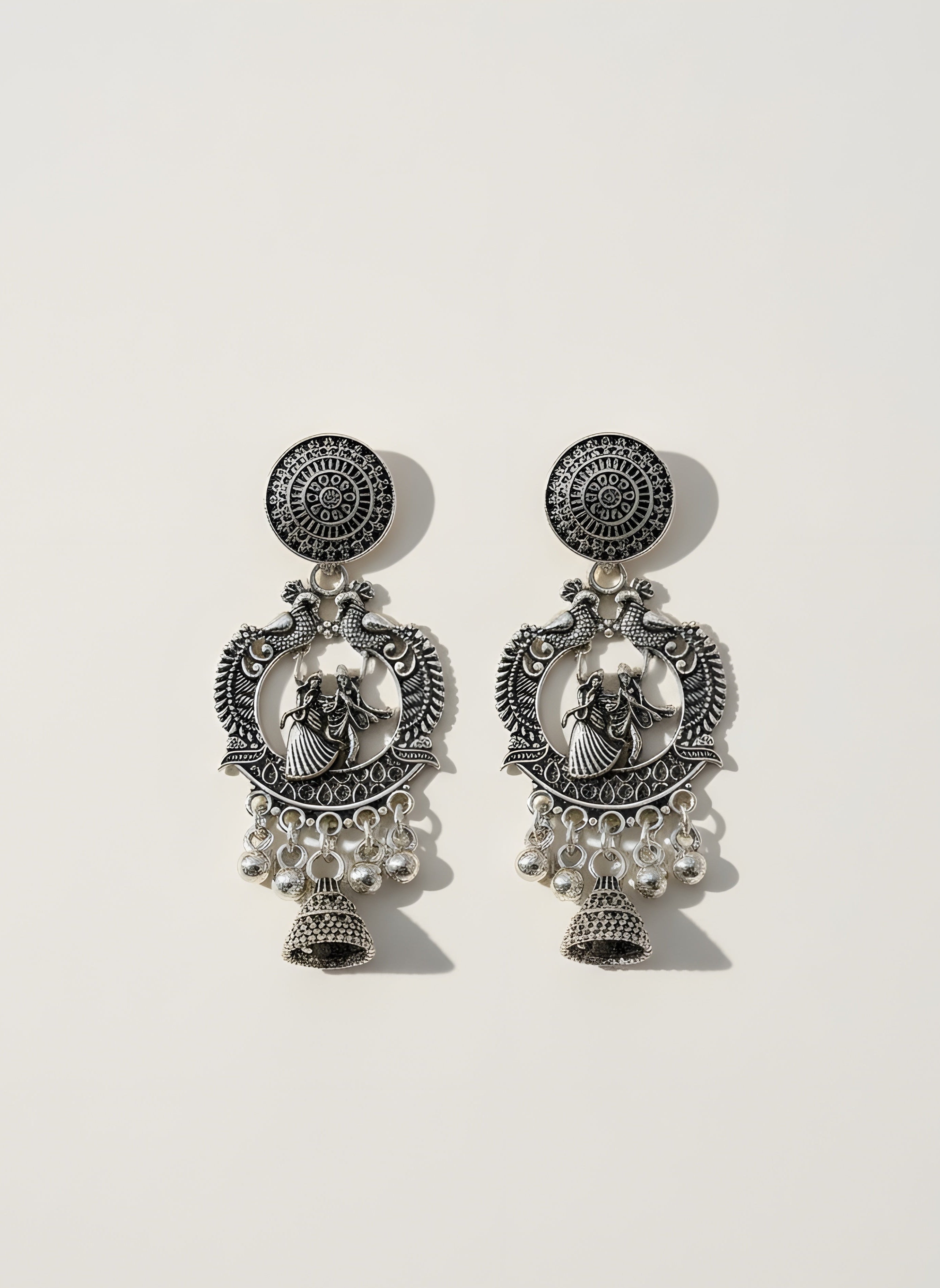 Pair of silver earrings with intricate designs on a white background