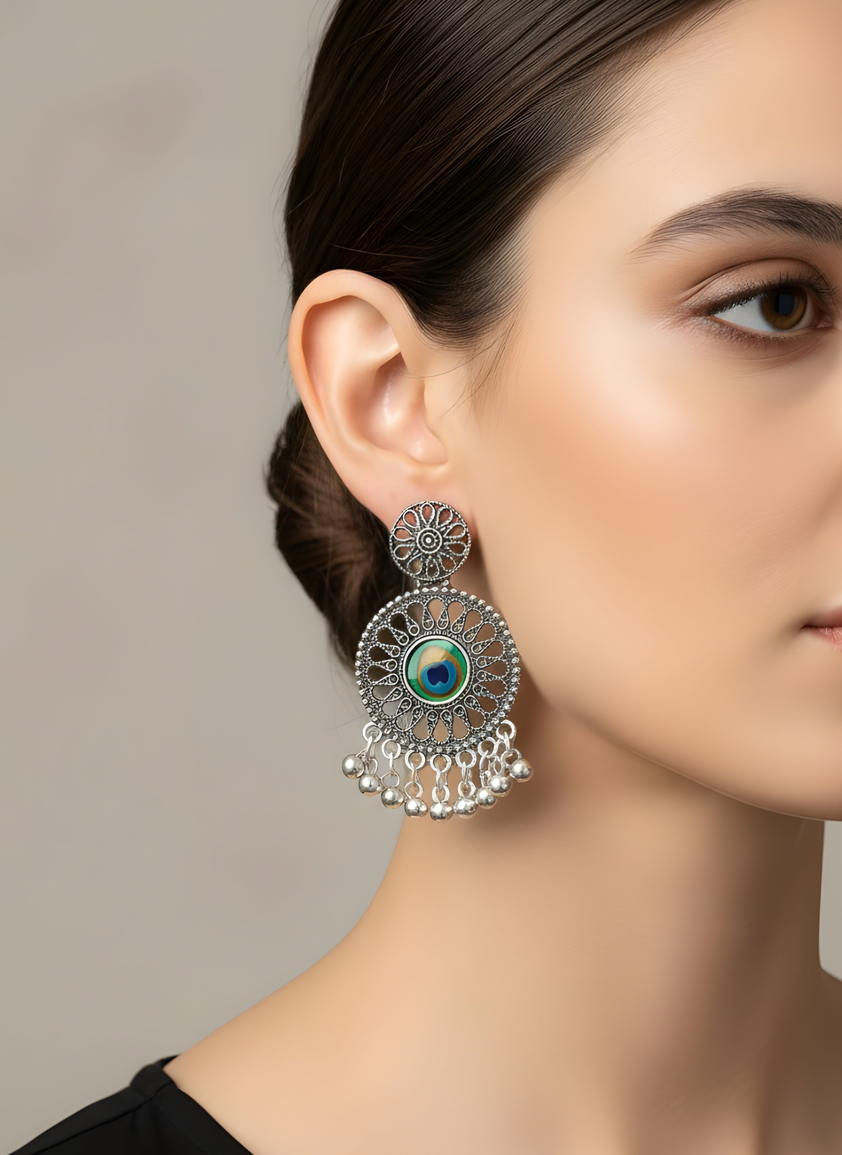 Close-up of a woman wearing a decorative earring with a neutral background