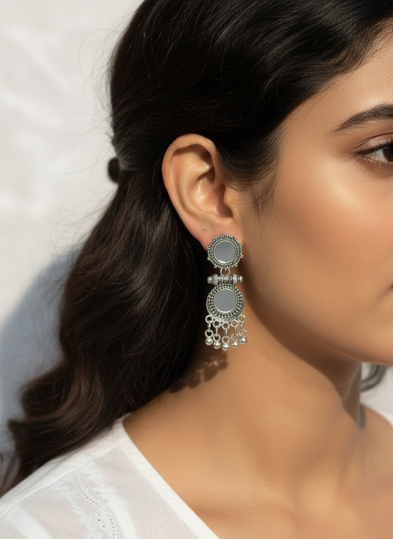 Close-up of a woman wearing silver earrings with a blurred background