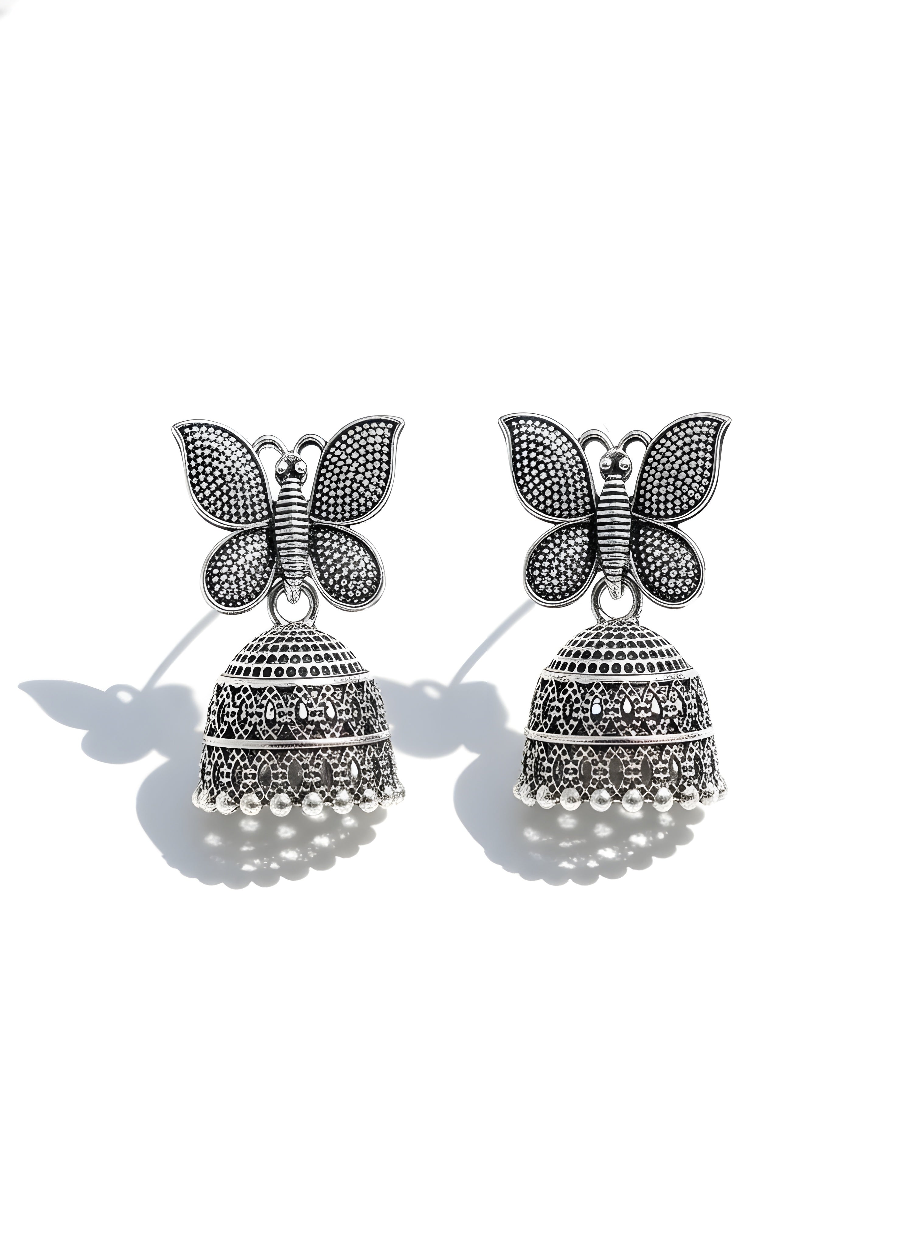 Butterfly-shaped earrings with bell designs on a white background