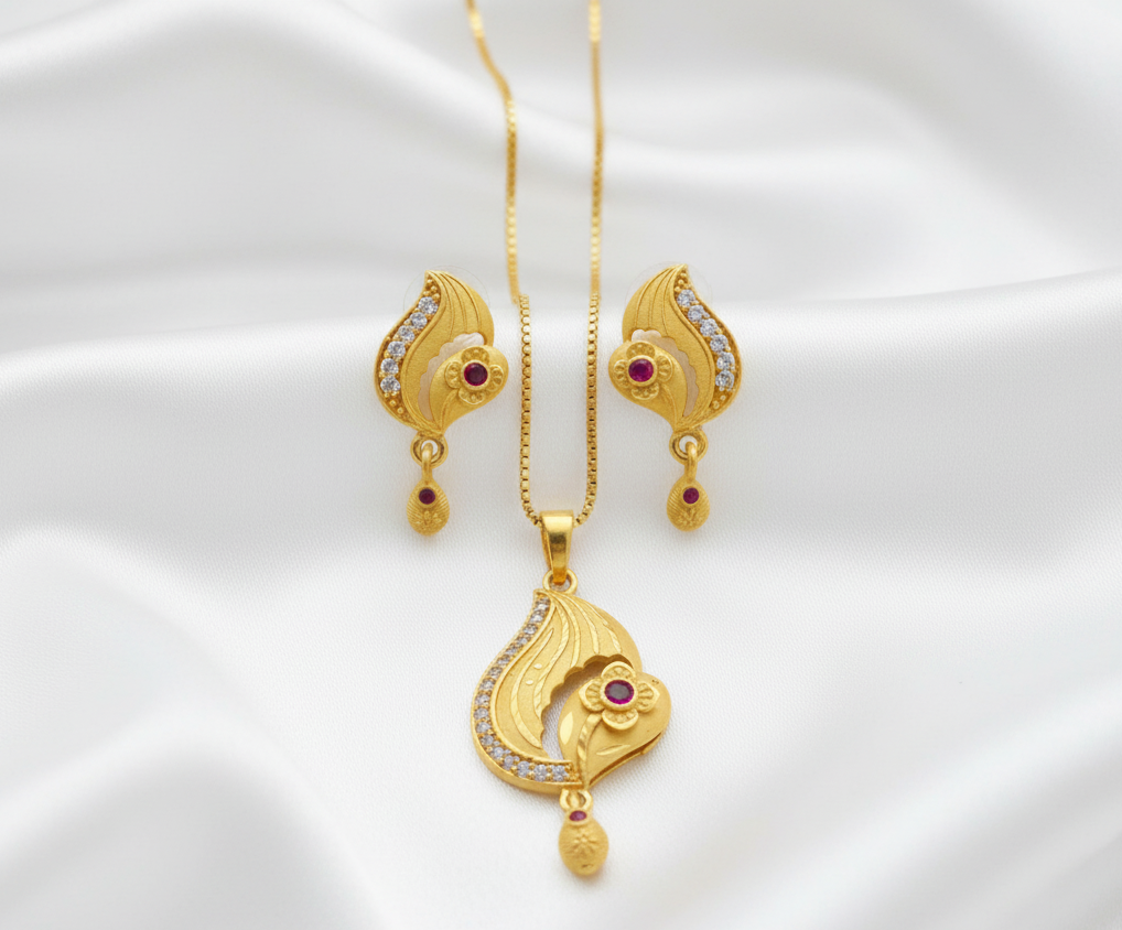 Gold jewelry set with necklace, pendant, and earrings on a white satin background