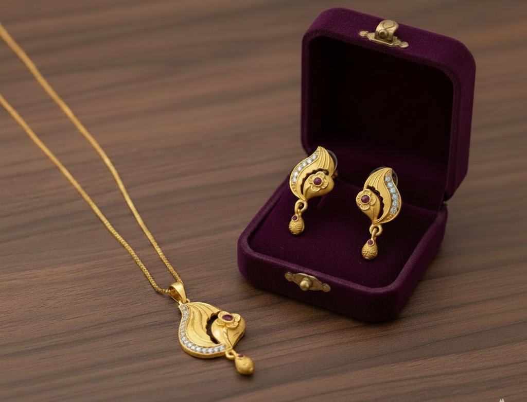 Gold necklace and earrings in a purple jewelry box on a wooden surface