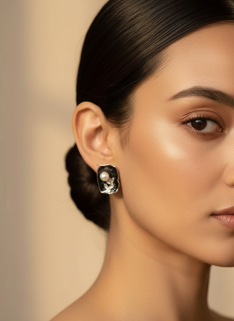 Close-up of a woman wearing a pearl earring with a neutral background
