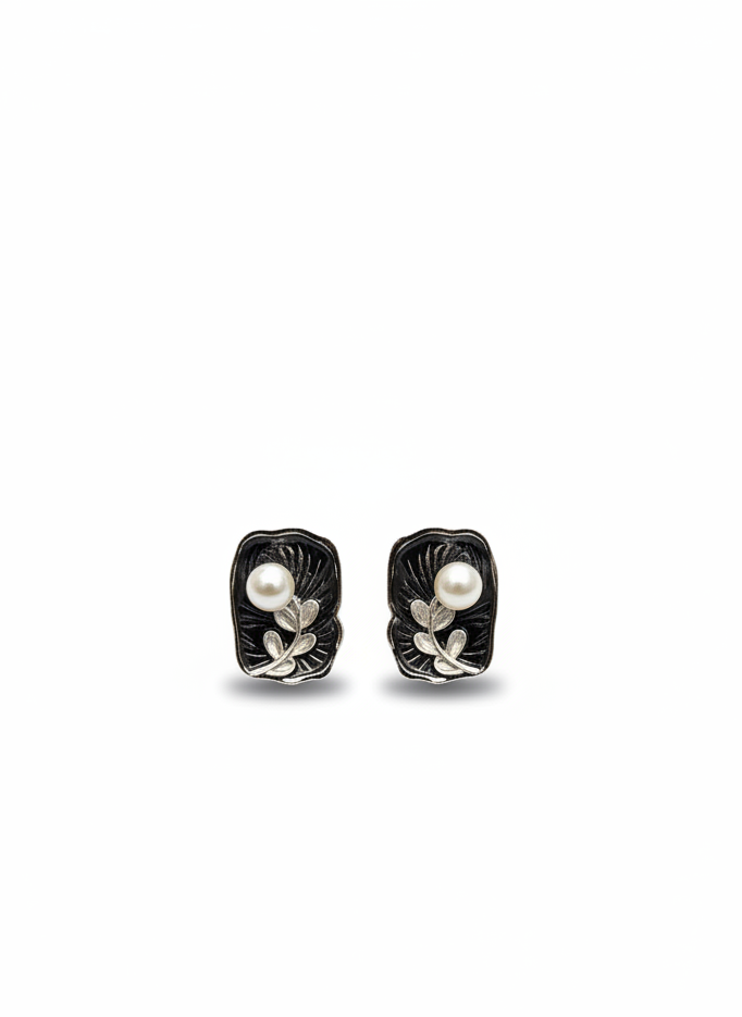 Pair of black and silver earrings with pearls on a white background