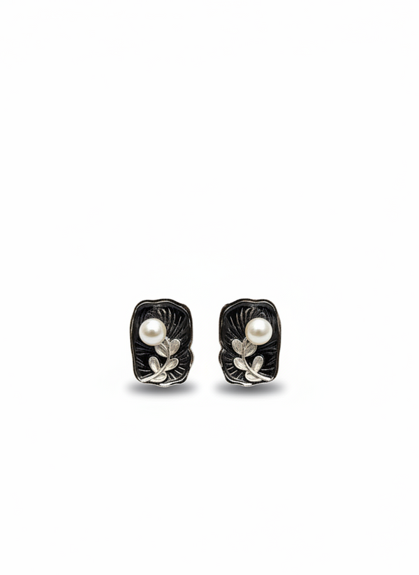 Pair of black and silver earrings with pearls on a white background