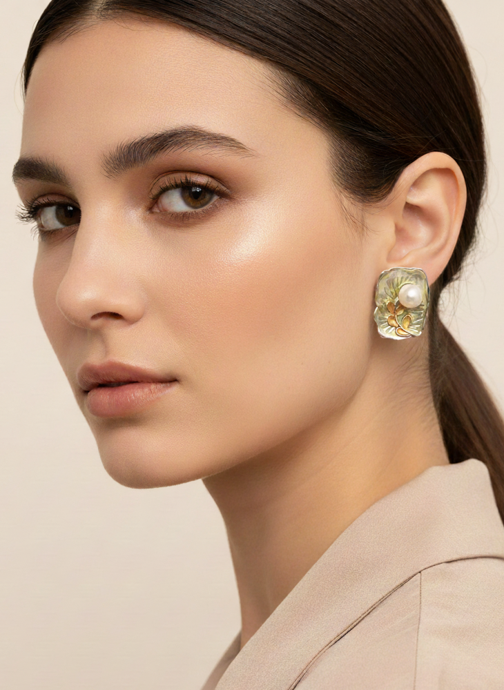 Woman wearing a gold earring with a beige background