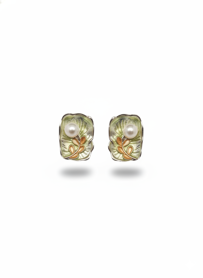 Pair of earrings with floral design and pearl center on a white background