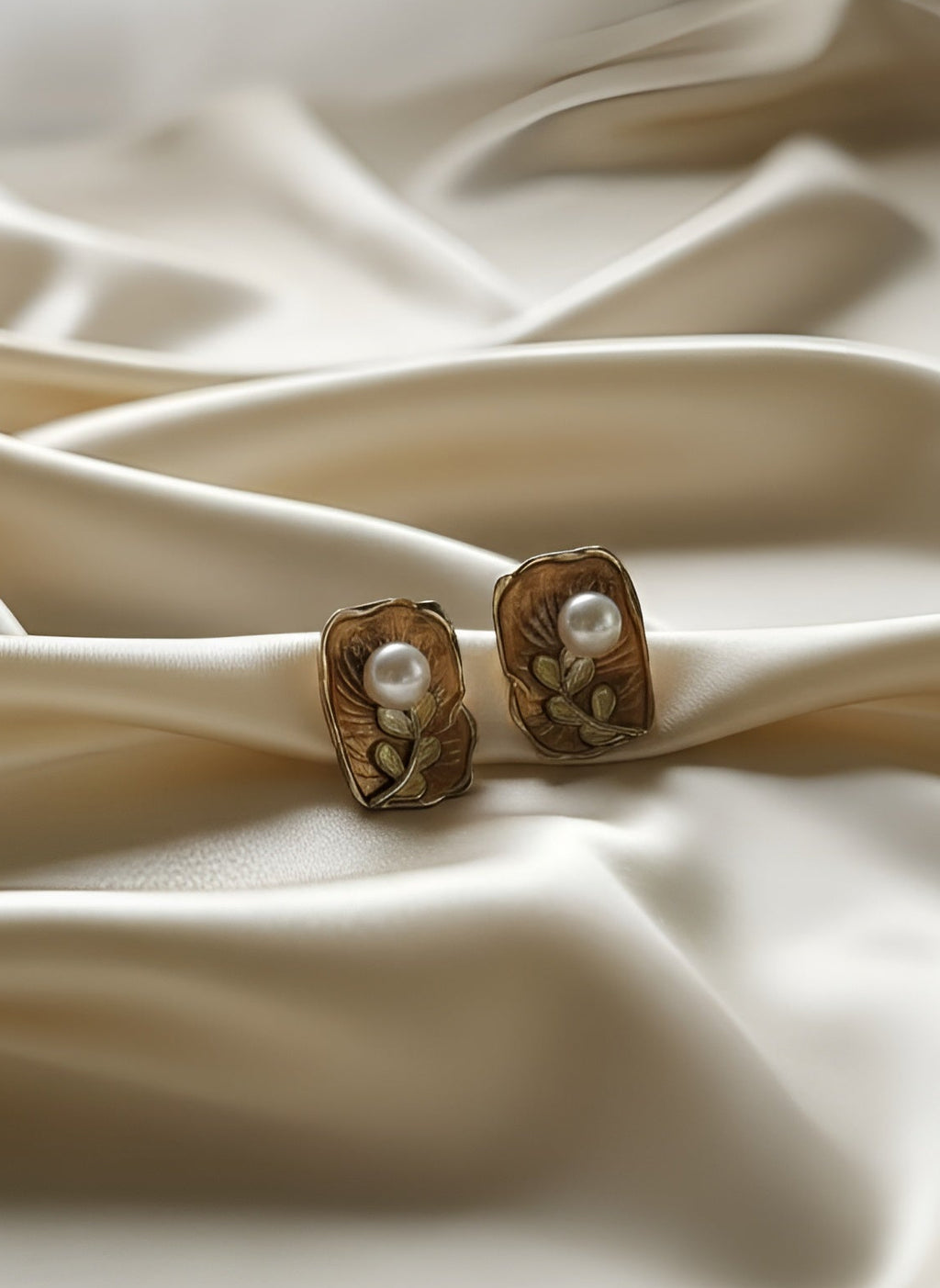 Pair of earrings on a textured beige fabric background