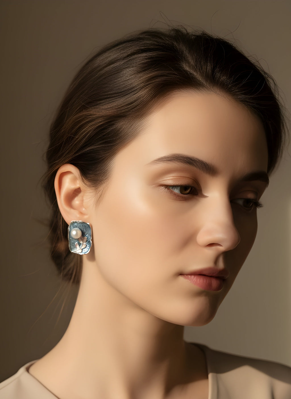 Woman wearing a pair of earrings with a neutral background