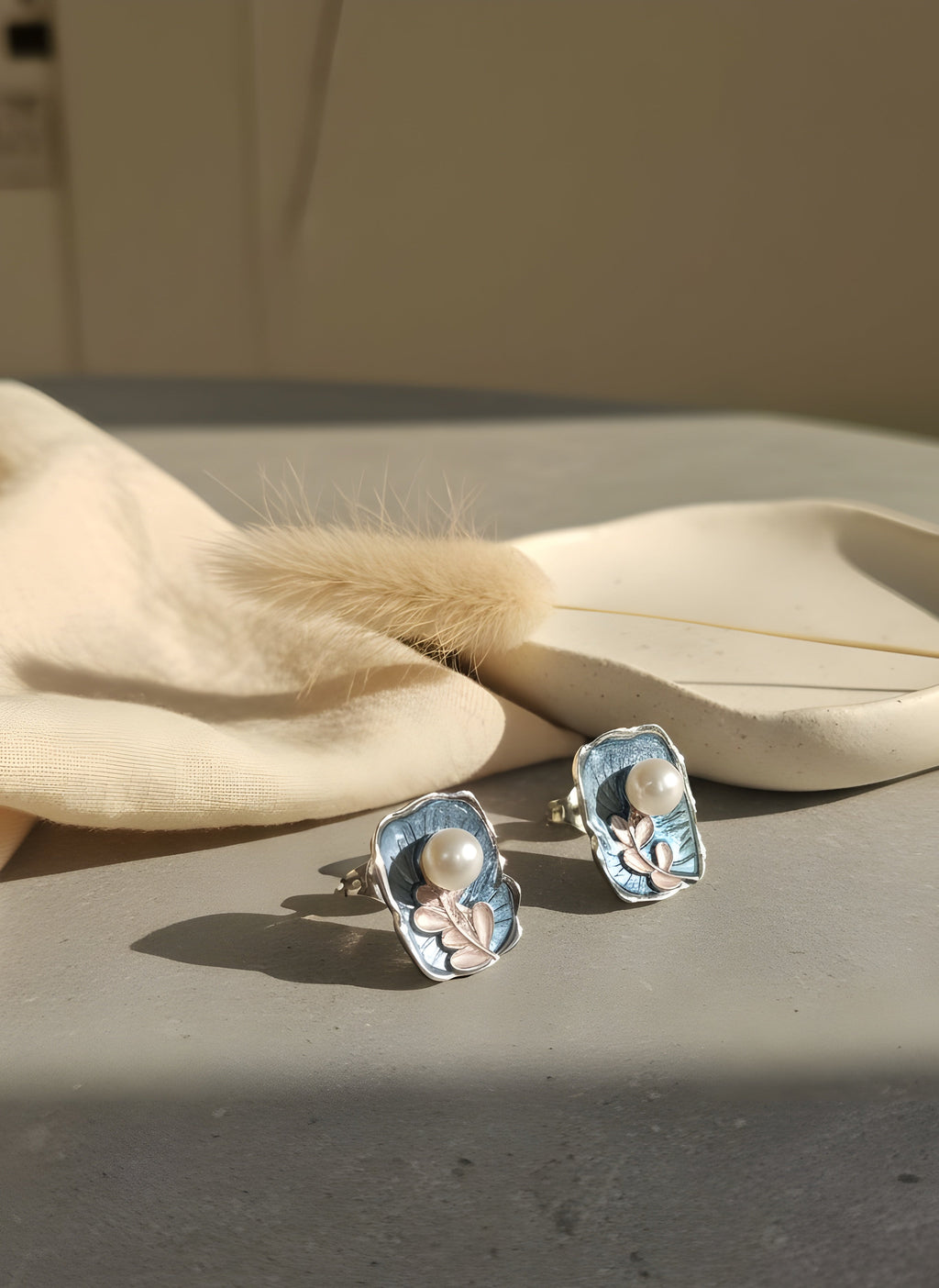 Pair of earrings on a textured surface with a neutral background