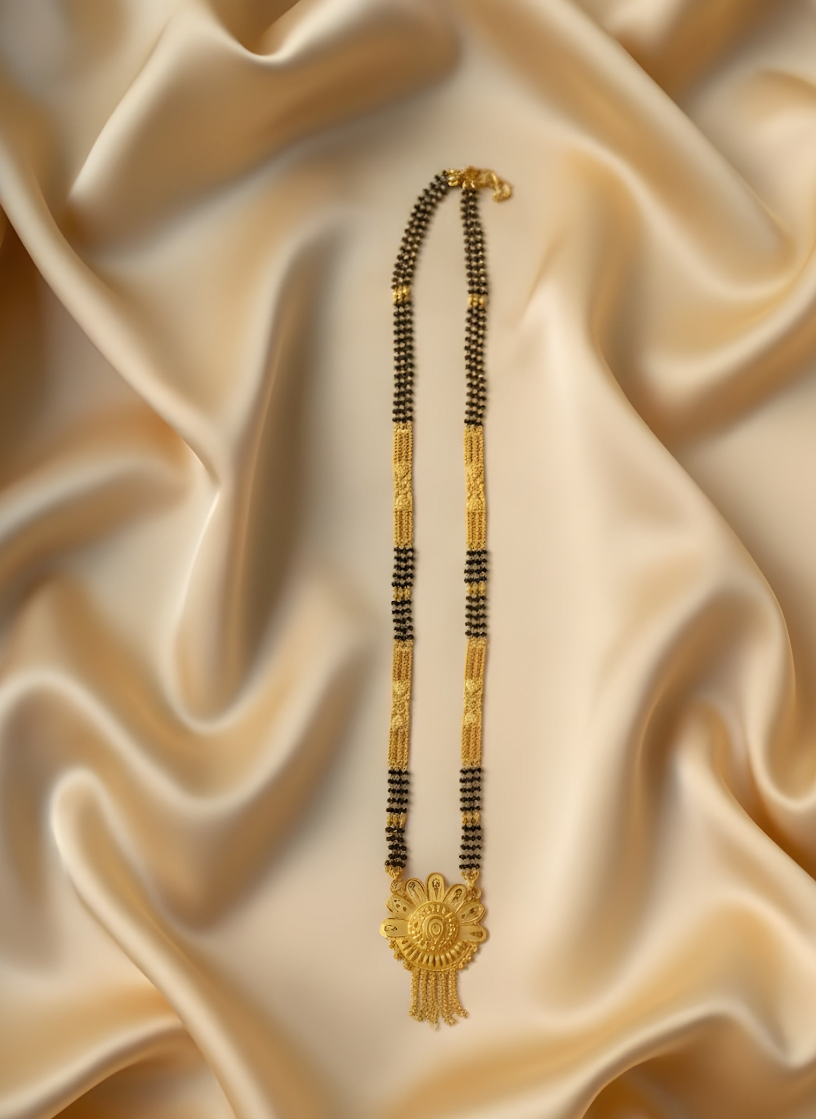 Gold and black beaded necklace on a beige satin fabric