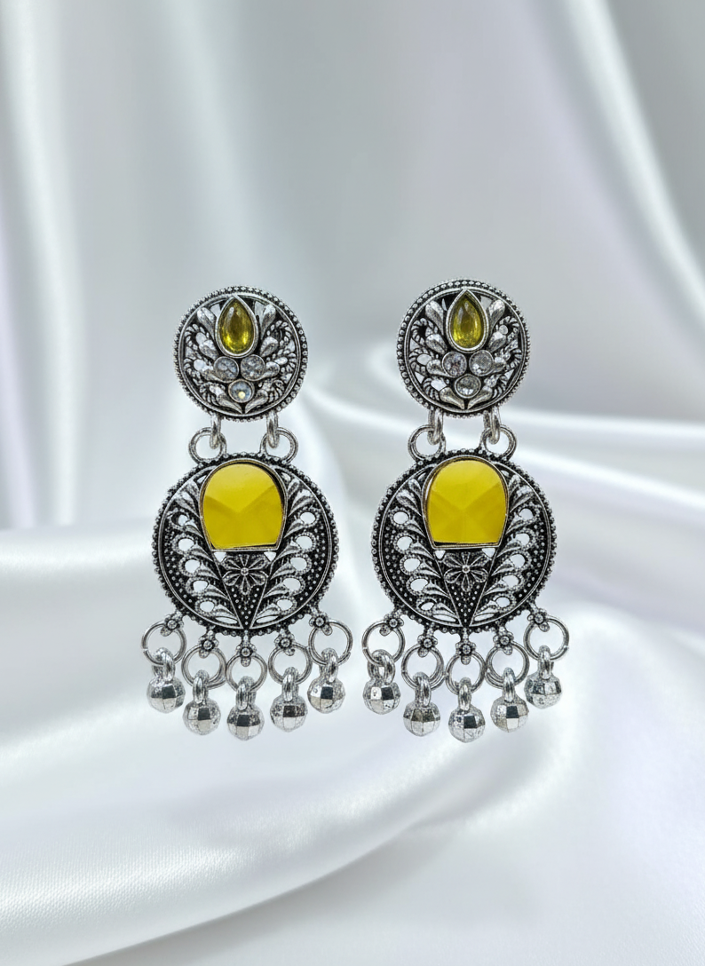 Pair of silver earrings with yellow stones on a white background