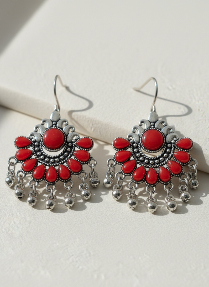 Pair of red and silver earrings on a light background