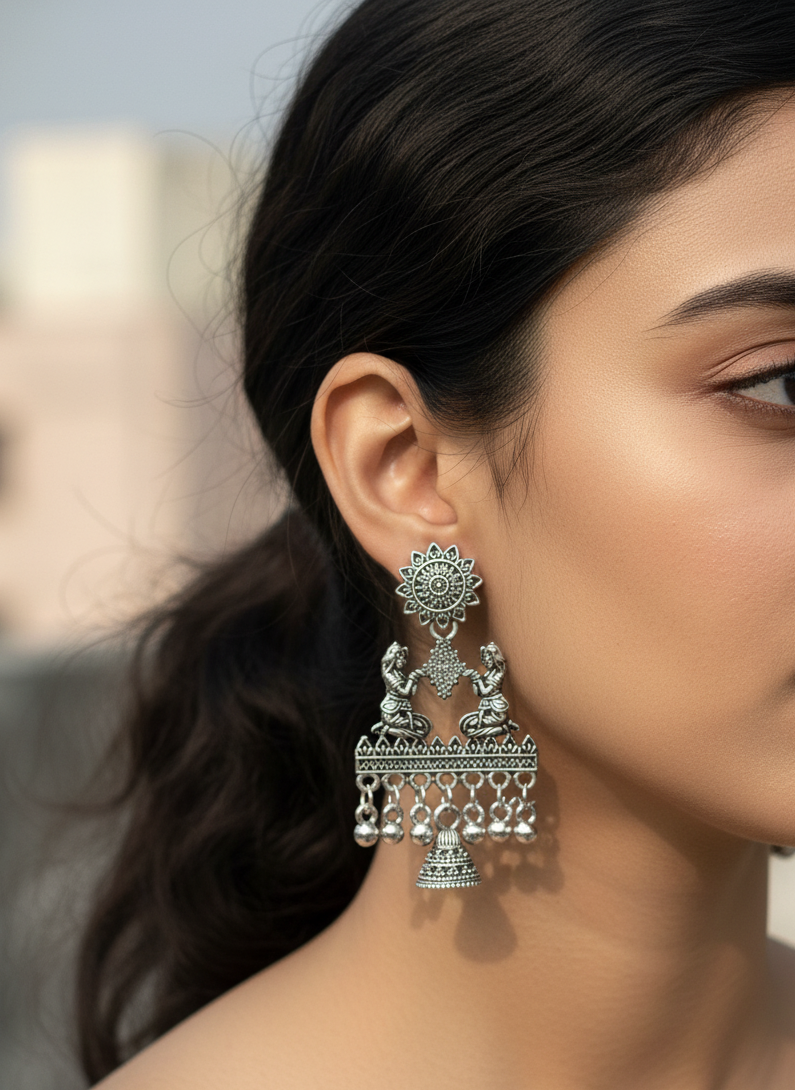 Close-up of a woman wearing silver earrings with intricate designs.