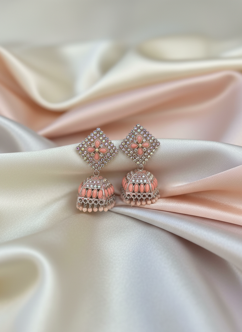 Pair of pink earrings on a satin fabric background
