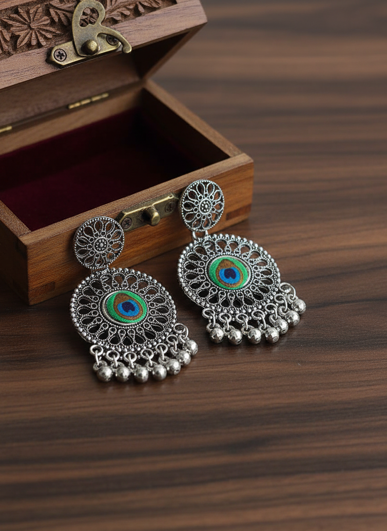 Decorative silver earrings with gemstones on a wooden surface