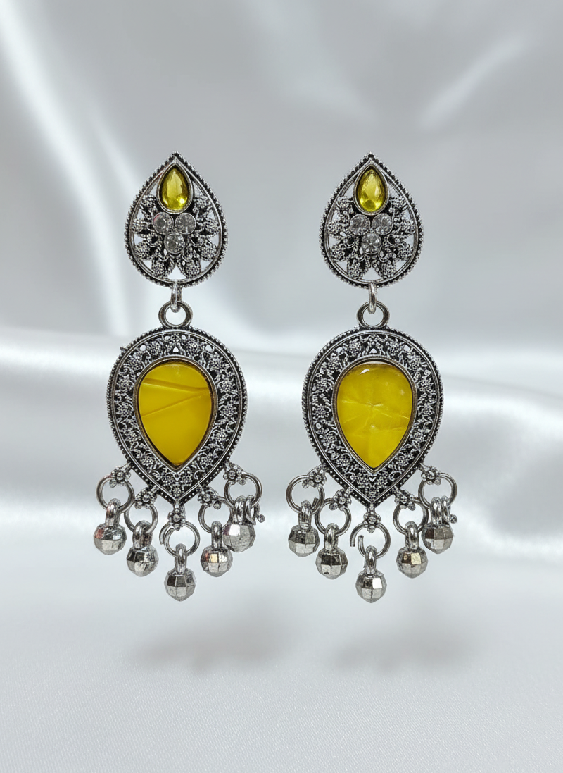 Pair of silver earrings with yellow stones on a satin background