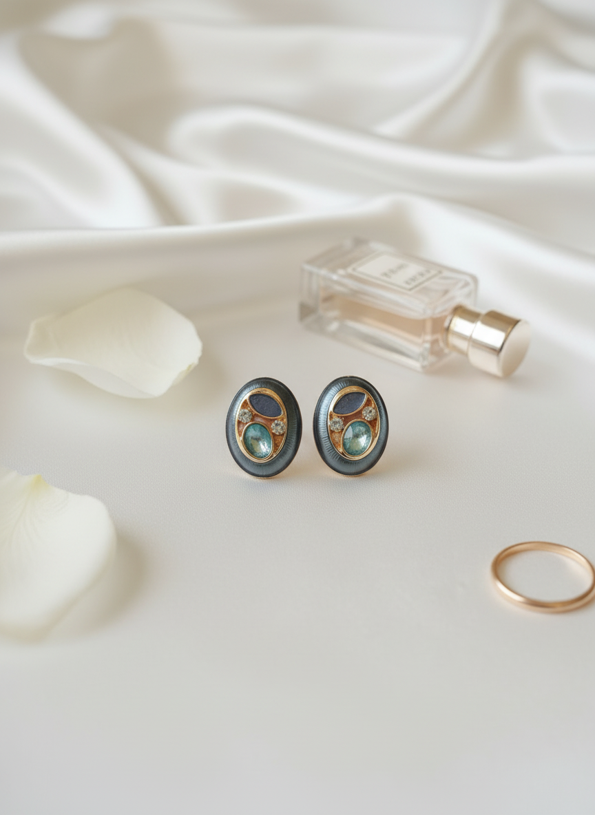 Pair of earrings with a ring and perfume bottle on a white fabric background