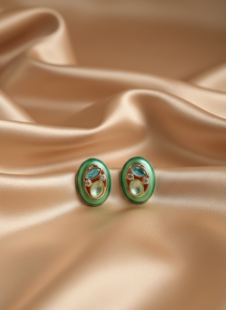 Pair of green earrings on beige satin fabric